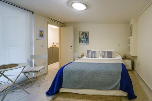 ein Schlafzimmer mit einem Bett, einem Tisch und einem Stuhl in der Unterkunft Studio Krinon - Paleo Psychiko in Athen