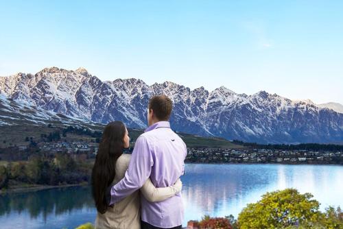 a man and a woman standing on top of a mountain at Swiss-Belsuites Pounamu Queenstown in Queenstown