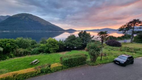 a car parked on the side of a road near a lake at The Lodge On The Loch Onich in Onich