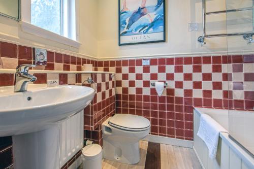 a bathroom with a sink and a toilet and a tub at The Portland Hotel in Lybster