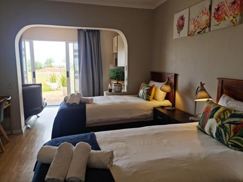 Habitación de hotel con 2 camas y ventana en Africatamna Self Catering House, en Durban