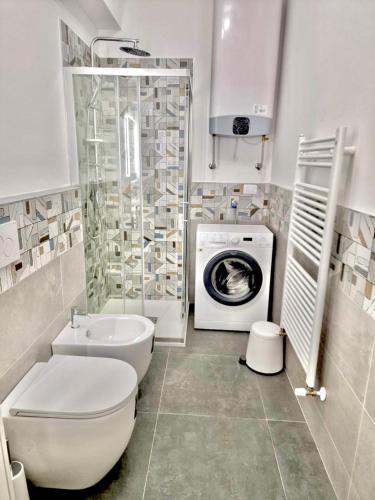La salle de bains est pourvue de toilettes et d'un lave-linge. dans l'établissement FriendlyHouse, à Bologne