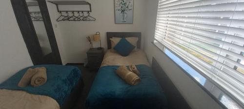 two beds in a small room with two windows at 6-min Walk to New Cross Parking Long Stay Discounts in Fallings Park