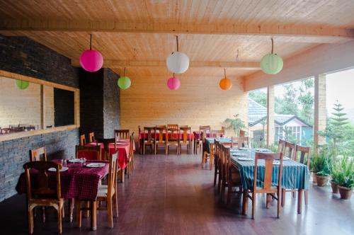 a dining room with tables and chairs and colorful lights at Oakwood Hamlet Resort in Shogi