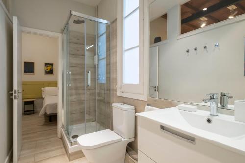 y baño con ducha, aseo y lavamanos. en Aspasios Gracia Apartments, en Barcelona