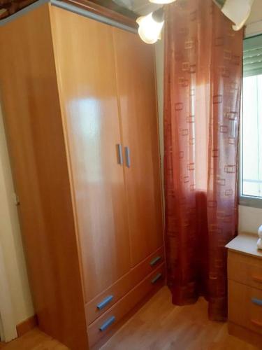 um grande armário de madeira num quarto com uma janela em Rooms 2 and 1 Beds near Sevilla Center em Sevilha