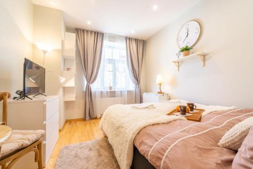 a bedroom with a bed and a clock on the wall at Valdemara Design Studio Apartment in City Center in Rīga