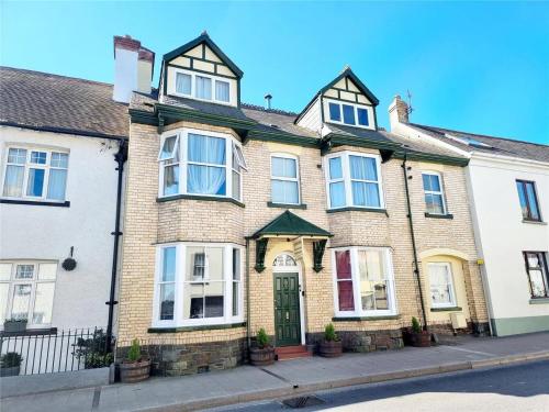 uma grande casa de tijolos ao lado de uma rua em Wyburn House em Great Torrington