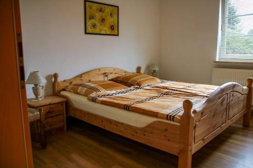uma grande cama de madeira num quarto com uma mesa em Ferienwohnung Erzgebirgsblick em Thermalbad Wiesenbad