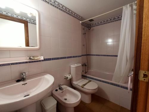 a bathroom with a sink and a toilet and a mirror at BONITO APARTAMENTO UN DORMITORIO 1ª LINEA DE PLAYA in Isla Canela