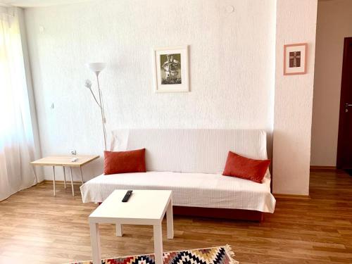 a white living room with a couch and a table at Sunny Home in Sandanski
