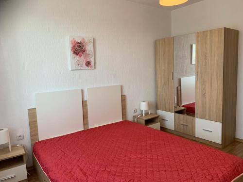 a bedroom with a red bed and a mirror at Sunny Home in Sandanski
