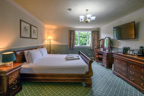 a bedroom with a bed and a television in it at The Portland Hotel in Lybster