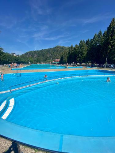 a row of blue swimming pools with people in them at Chata Polomka s Jacuzzi - Vidíte deti na dvore z obývačky - Pri potoku - Výhľad na Polomské Očko in Brezno