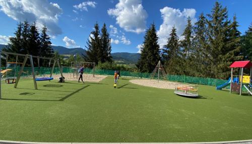 a group of people playing on a playground at Chata Polomka s Jacuzzi - Vidíte deti na dvore z obývačky - Pri potoku - Výhľad na Polomské Očko in Brezno