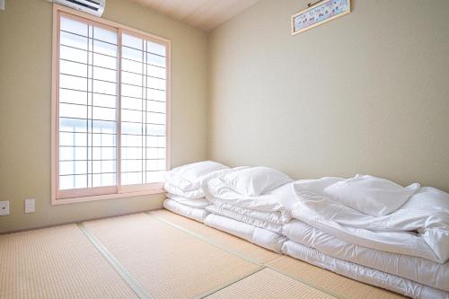 um quarto com uma cama não feita em frente a uma janela em Bungetsu Shokaku Kaikan em Quioto