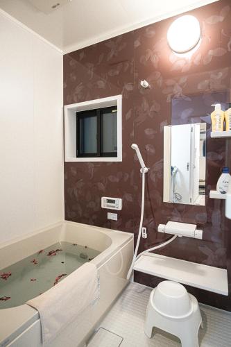 a bathroom with a tub and a toilet and a sink at Bungetsu Shokaku Kaikan in Kyoto