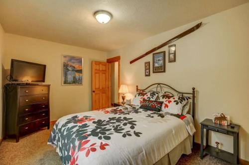 a bedroom with a bed and a dresser and a television at 1 Particular Pine by Casago McCall - Donerightmanagement in McCall