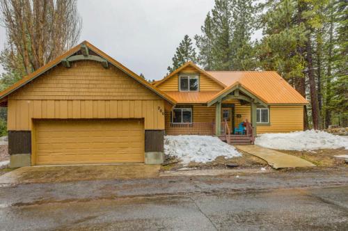a yellow house with a garage at 1 Particular Pine by Casago McCall - Donerightmanagement in McCall