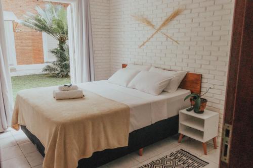 - une chambre avec un lit, une table et une horloge murale dans l'établissement Yabás Praia, à Ubatuba