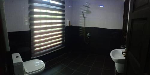 a black bathroom with a toilet and a sink at Captain's Cabin Resort - Naval Heritage (Swimming Pool) in Kota Bharu