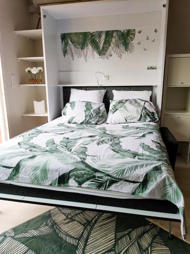 - une chambre avec un lit et une couette verte dans l'établissement A 500 m bord de mer Giens, à Hyères