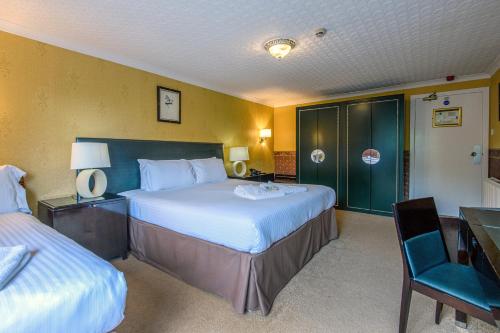 a hotel room with two beds and a desk and chair at The Portland Hotel in Lybster