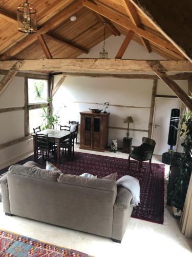 a living room with a couch and a table at The Barn in Romsey