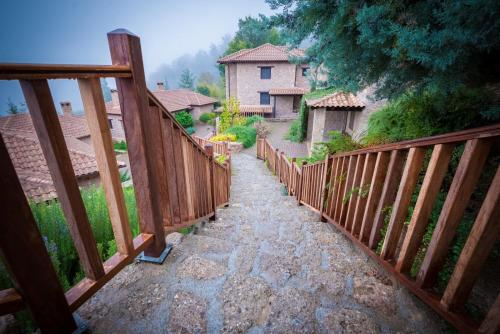 a wooden fence on a walkway in a yard at Pliadon Gi Mountain Resort & Spa in Kato Trikala Korinthias