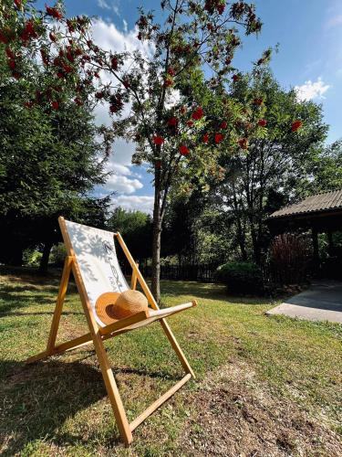 a chair with a hat sitting in the grass at Chata Na Krańcu Świata in Łączna