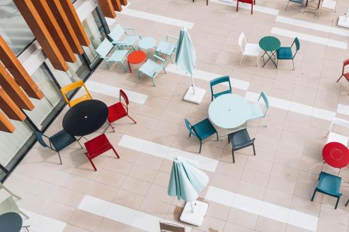 an overhead view of a cafeteria with tables and chairs at ibis Budget La Rochelle Centre gare in La Rochelle