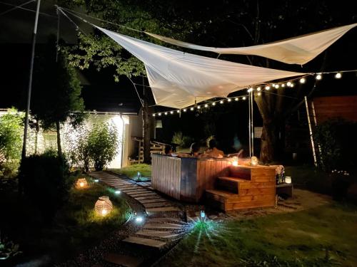 a tent in a garden at night with lights at Chata Na Krańcu Świata in Łączna