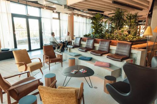 a lobby with chairs and tables and people sitting at ibis Budget La Rochelle Centre gare in La Rochelle