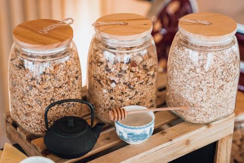 three jars of granola on a wooden table at ibis Budget La Rochelle Centre gare in La Rochelle