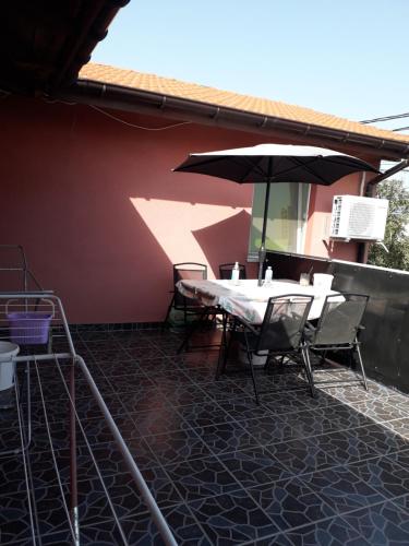 a table and chairs with an umbrella on a patio at Vila Roz in Mangalia