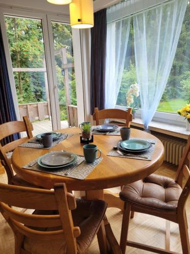mesa de comedor con sillas y ventana grande en Ferienhaus Monarda, en Hahnenklee-Bockswiese