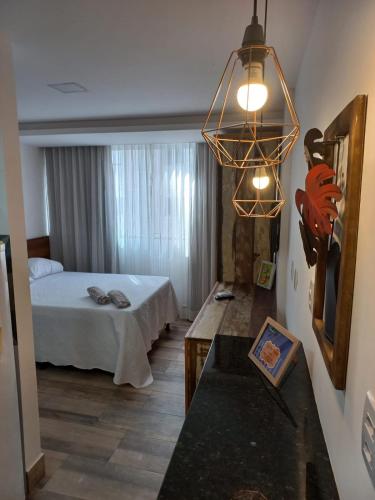 ein Hotelzimmer mit einem Bett und einem Tisch in einem Zimmer in der Unterkunft FLAT Beverly Hills 401B in Vila Velha