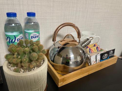 a tray with a tea kettle and two bottles of water at Luxury Condo in Clark Pampanga beside Hilton Hotel and Casino in Angeles