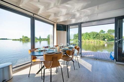 a dining room with a table and chairs and water at Surla luxury sailing Houseboat Splendid at Marina Monnickendam in Monnickendam