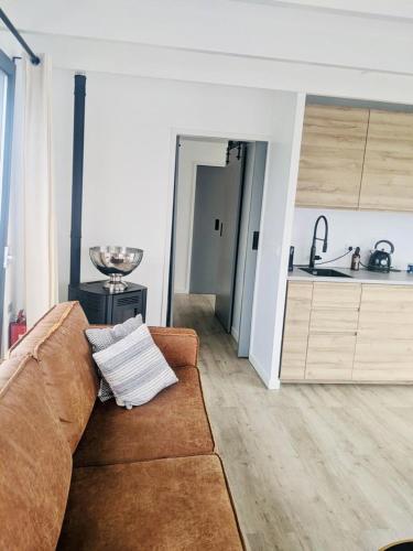 a living room with a couch and a kitchen at Surla luxury sailing Houseboat Splendid at Marina Monnickendam in Monnickendam