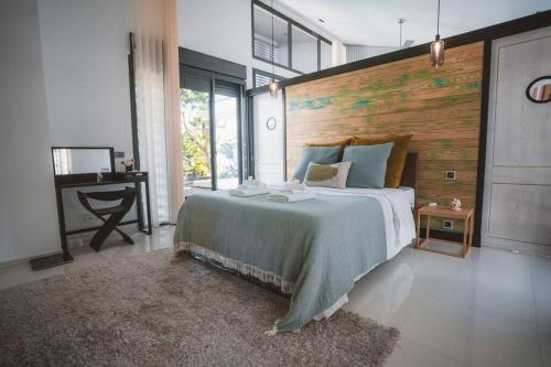 um quarto com uma cama grande e uma parede de madeira em Villa Camilla, des vacances hors du temps em Saint-Pierre