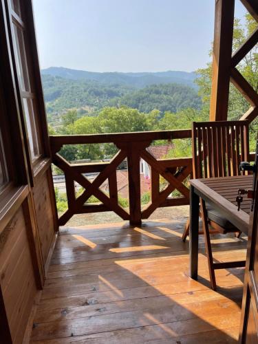 a porch with a bench and a view of the mountains at Konačište Osmica in Mokra Gora