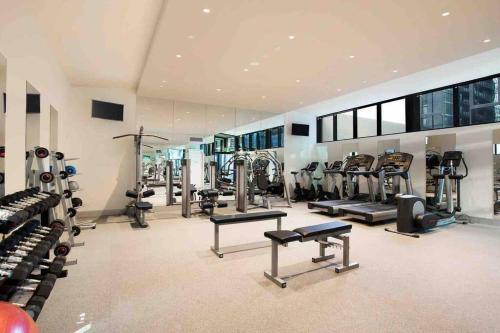 a gym with a lot of treadmills and machines at Modern 3 Bedroom Apartment in Southbank in Melbourne