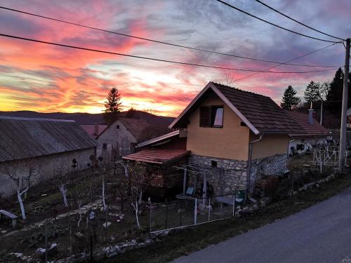 a house with a sunset in the background at smještaj Mala Zidanica in Tomaševci