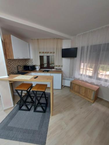 a kitchen with a table and some chairs in a room at STIV Apartmani in Lukovo