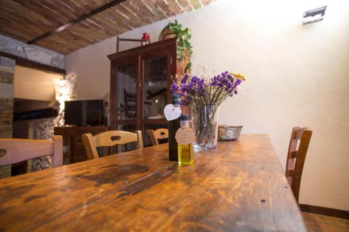 a wooden table with a vase of flowers on it at Casetta la Crus - Romantic house in Musellaro