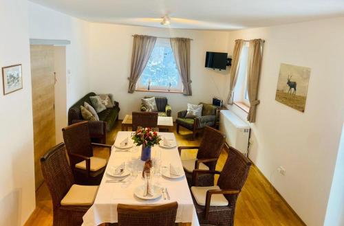 a dining room with a table and chairs and a living room at Wildbach Chalet Turrach in Turracher Hohe