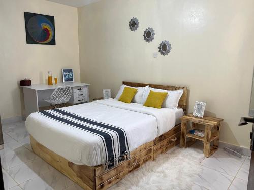 Un dormitorio con una gran cama de madera con almohadas amarillas. en Ruby Modern Homes-1br-Nyeri, King'ong'o-Marriott en Nyeri