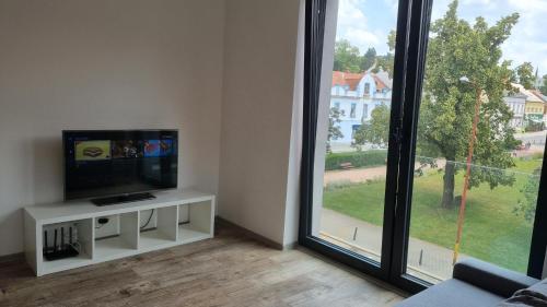 a living room with a tv and a large window at Lovely 1 bedroom apt in middle of city centre in Blansko