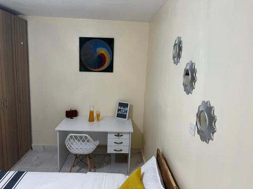 1 dormitorio con escritorio y una pintura en la pared en Ruby Modern Homes-1br-Nyeri, King'ong'o-Marriott, en Nyeri